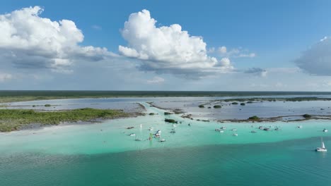Aerial-view-towards-a-lot-of-boats-at-the-Canal-de-los-Piratas,-in-the-Bacalar-Lagoon,-in-sunny-Mexico