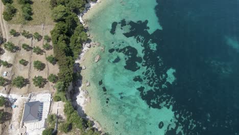 Drone-hovers-above-surface-of-the-sea-and-land-of-Zakynthos,-Greece