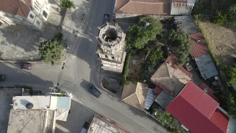 Drone-pans-over-a-small-town,-circling-the-central-tower,-on-the-island-of-Zakynthos,-Greece