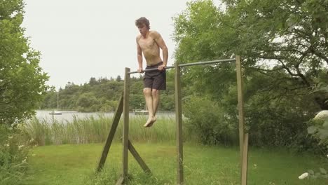 Youth-motivated-athletic-man-performs-dips-on-outdoor-home-gym