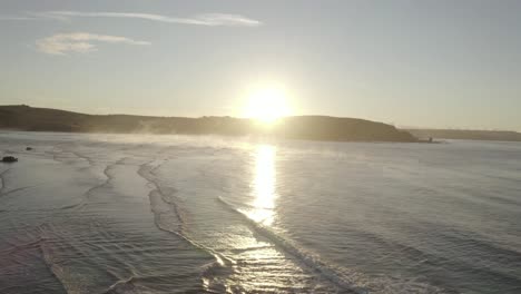 Panning-Aerial-Truck-Shot-of-Bantham-Beach-at-Sunrise-with-Steam-rising-off-the-ocean