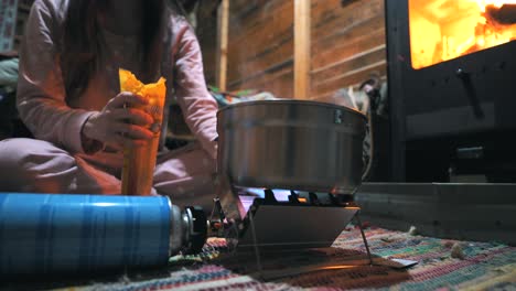 Cooking-pasta-with-a-portable-gas-stove-in-a-cottage-in-the-Nature,-Outdoor,-Camping