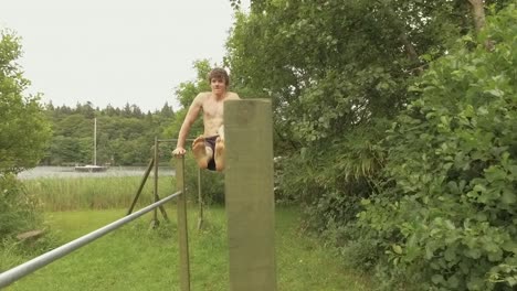 Fit-young-man-performs-L-Sit-core-strength-exercise-on-parallel-posts