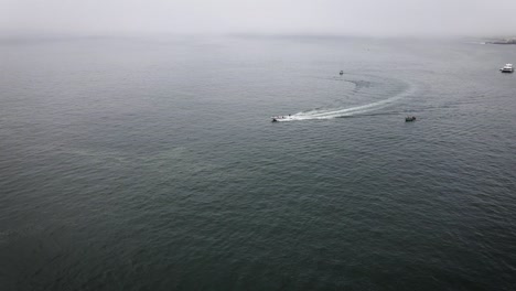 Drohnenaufnahme-Einer-Person,-Die-In-Einem-Boot-In-Lima,-Peru,-Im-Ozean-Wakeboarden-Geht
