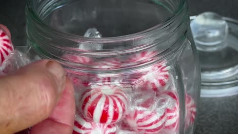A-greedy-man-quickly-takes-out-lots-of-lollies-from-a-glass-jar