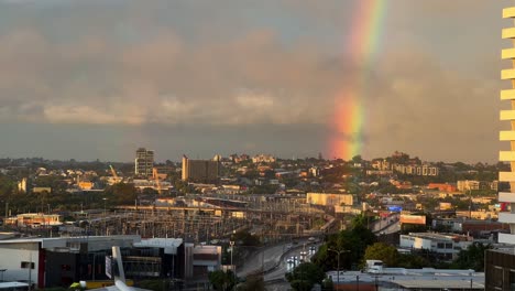 Sky-clear-up-after-a-heavy-rainfall-in-the-afternoon,-beautiful-rainbow-with-golden-sun-shinning-across-Bowen-Hills-inner-city-suburb-of-Brisbane,-South-East-Queensland