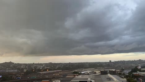 Dramatic-time-lapse-shot-capturing-dark-and-dense-rainstorm-clouds-accumulating-and-forming-in-the-sky-and-sudden-flash-heavy-rain-across-Brisbane-city,-Queensland,-Australia