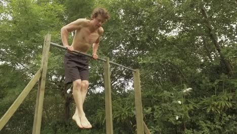 Young-athletic-man-performs-straight-bar-dips-on-outdoor-gym