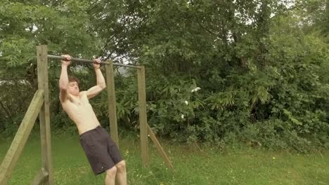 Young-athletic-man-doing-explosive-pullups-on-outdoor-home-gym