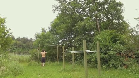 Young-shirtless-man-running-to-train-at-home-gym-outdoors-in-nature