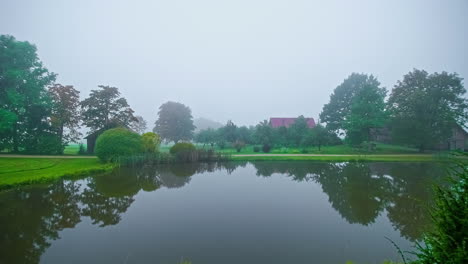 A-misty,-foggy-day-at-a-countryside-cottage-and-lake-in-autumn---time-lapse