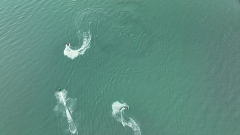Top-View-Of-Jet-Skiers-Speeding-And-Circling-On-Turquoise-Waters