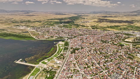 Beyşehir-Türkei-Luftbild-V3-Filmische-Hochwinkelschwenkansicht,-Drohnenüberführung-über-Der-Seeuferstadt,-Die-Die-Wunderschöne-Landschaft-Des-Süßwassersees-Mit-Bergblick-Einfängt---Aufgenommen-Mit-Mavic-3-Cine---Juli-2022