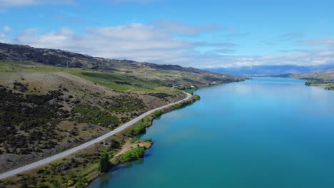 Drohne-Um-Die-Straße,-Die-Entlang-Des-Blauen-Neuseeländischen-Sees-Verläuft