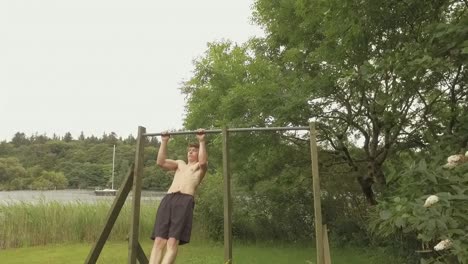 Athletic-young-man-reps-pullups-on-home-outdoor-gym-Slow-Motion