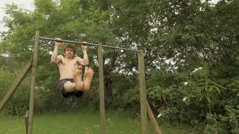 Athletic-young-man-does-L-Sit-pullups-on-outdoor-home-gym