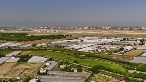Antalya-Turkey-Aerial-v56-flyover-farmland-in-yenigöl-filled-with-horticulture-plastic-air-insulated-greenhouse-with-duden-stream-running-across-with-airport-view---Shot-with-Mavic-3-Cine---July-2022
