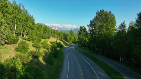Szenische-Fahrstrecke-Mit-Asphaltierter-Straße-Und-Radweg-Zwischen-üppiger-Vegetation-Auf-Sommerblauem-Himmelshintergrund-In-Anchorage,-Alaska