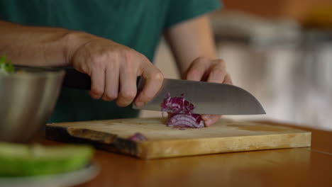 Close-up-man-cutting-onion-on-wooden-board,-making-Salad-concept