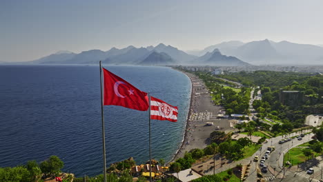 Antalya-Turkey-Aerial-v13-panoramic-view-drone-fly-around-turkish-national-and-antalyaspor-flags-in-meltem-capturing-konyaaltı-beach-with-mountain-silhouette-view---Shot-with-Mavic-3-Cine---July-2022