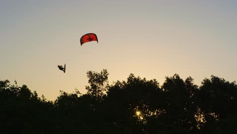 Kitesurfer-Kommen-Während-Der-Kiteloop-bewegung-Gegen-Den-Goldenen-Stundenhimmel-In-Die-Luft