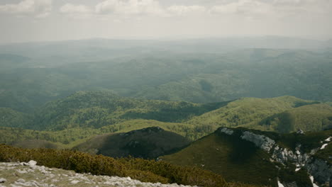 A-view-from-the-peak-of-mountain-Snežnik,-karst-terrain-with-green-scenery-and-white-rocks