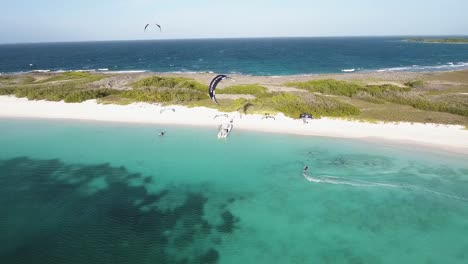 Man-kiteboard-along-white-sand-SHORE-beach,-CRASQUI-ISLAND,-FROM-RIGHT-TO-LEFT