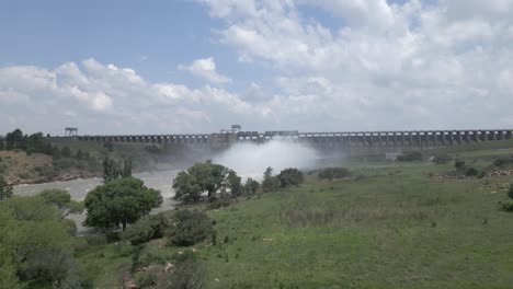 Aerial-approaches-hydro-dam-from-downstream-as-water-is-released
