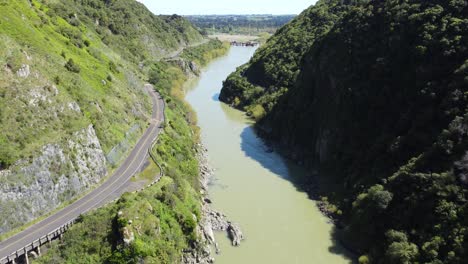 A-low-flythrough-the-Manawatu-Gorge,-next-to-the-abandoned-road,-New-Zealand