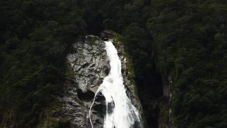 Powerful-waters-of-Lady-Bowens-waterfall-flow-down-the-slope-bearween-deep-green-forest-in-Milford-sound,-Southland,-South-Island,-New-Zealand,-Fjordland-National-park