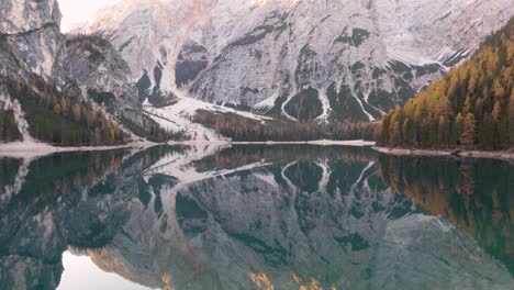 Aerial-Pan-Up-Reveals-Famous-Row-Boats-on-Lake-Braies-with-Mountain-in-Background