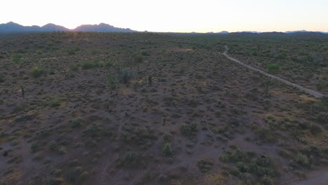 Tracking-drone-shot-of-roadway-that-runs-through-vacant-desert-at-sunset-located-near-Flagstaff-Arizona