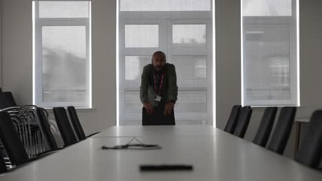 Nervous-asian-manager-alone-in-empty-meeting-room-waiting-for-colleagues