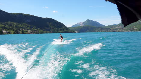 Wide-shot-of-wakesurfer-riding-the-waves-with-mountain-range-in-the-background