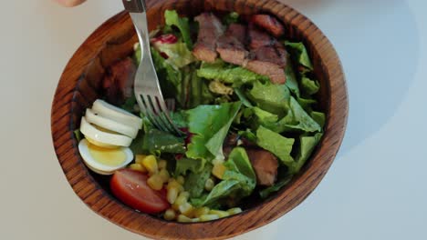 Frau-Isst-Frischen-Und-Gesunden-Salat-Auf-Holzschale-Mit-Einer-Gabel