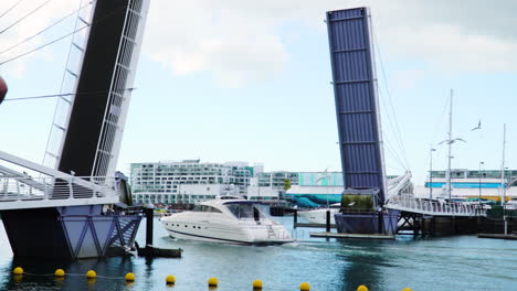A-yacht-sailing-under-the-tourist-bridge-in-Auckland,-New-Zealand