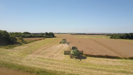 Aerial-Wide-Shot---Combined-Harvesters-Working-On-Rapeseed-Canola-Field-In-Countryside