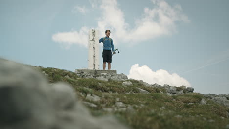 Hiker-reaches-a-rock-monument,-touches-it-and-continues-his-journey