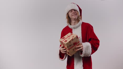 Der-Schreckliche-Weihnachtsmann-Gibt-Vor,-Ein-Geschenk-Nach-Dir-Zu-Werfen,-Beschließt,-Es-Dir-Stattdessen-Sanft-Mit-Einem-Breiten-Lächeln-Zu-Geben