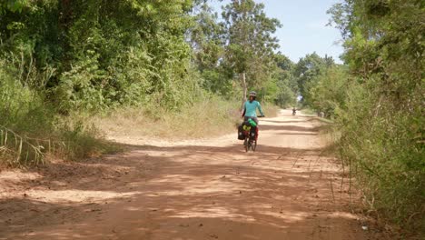 Women-long-distance-cyclist-riding-through-nature-trails-of-Thailand-in-a-hot-sunny-day