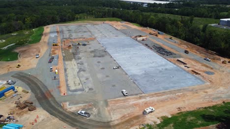 A-drone-flys-over-a-water-truck-at-a-construction-site-with-a-drying-concrete-pad