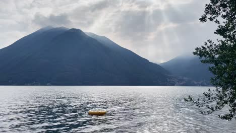 Mittelweite-Aufnahme-Des-Comer-Sees,-Italien-Mit-Einem-Kleinen-Gelben-Schlauchboot-Im-Vordergrund