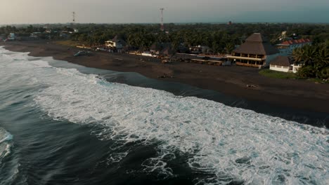 Aerial-Drone-View-Of-Crashing-Foamy-Waves-Rolling-Over-Black-Sand-Beach-Of-Monterrico,-Guatemala