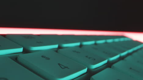 Close-up-tracking-shot-over-the-individual-keys-of-computer-keyboard-in-red-blue-technical-light