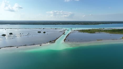 Aerial-view-overlooking-the-Canal-de-los-Piratas,-in-the-Bacalar-Lagoon,-in-sunny-Mexico---rising,-drone-shot