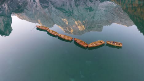 Filmszene,-Hölzerne-Ruderboote,-Pragser-Wildsee,-Unglaubliche-Bergspiegelung-Im-Hintergrund
