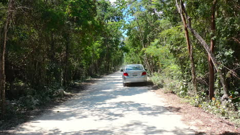 car-driving-off-road-on-dusty-jungle-path-in-Coba-Quintana-Roo-Mexico-on-sunny-summer-day