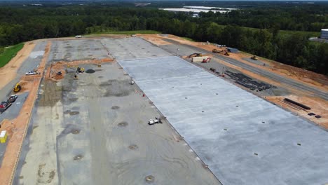 A-drone-files-over-a-construction-site-showing-off-the-progress-of-a-concrete-pad-drying