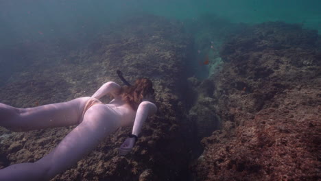 A-young-woman-swims-over-a-reef-at-Bonim-Beach,-Israel