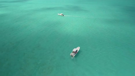 Aerial-zenith-view-two-motor-boats-stand-in-the-middle-of-the-caribbean-sea-turquoise-water,-Los-roques